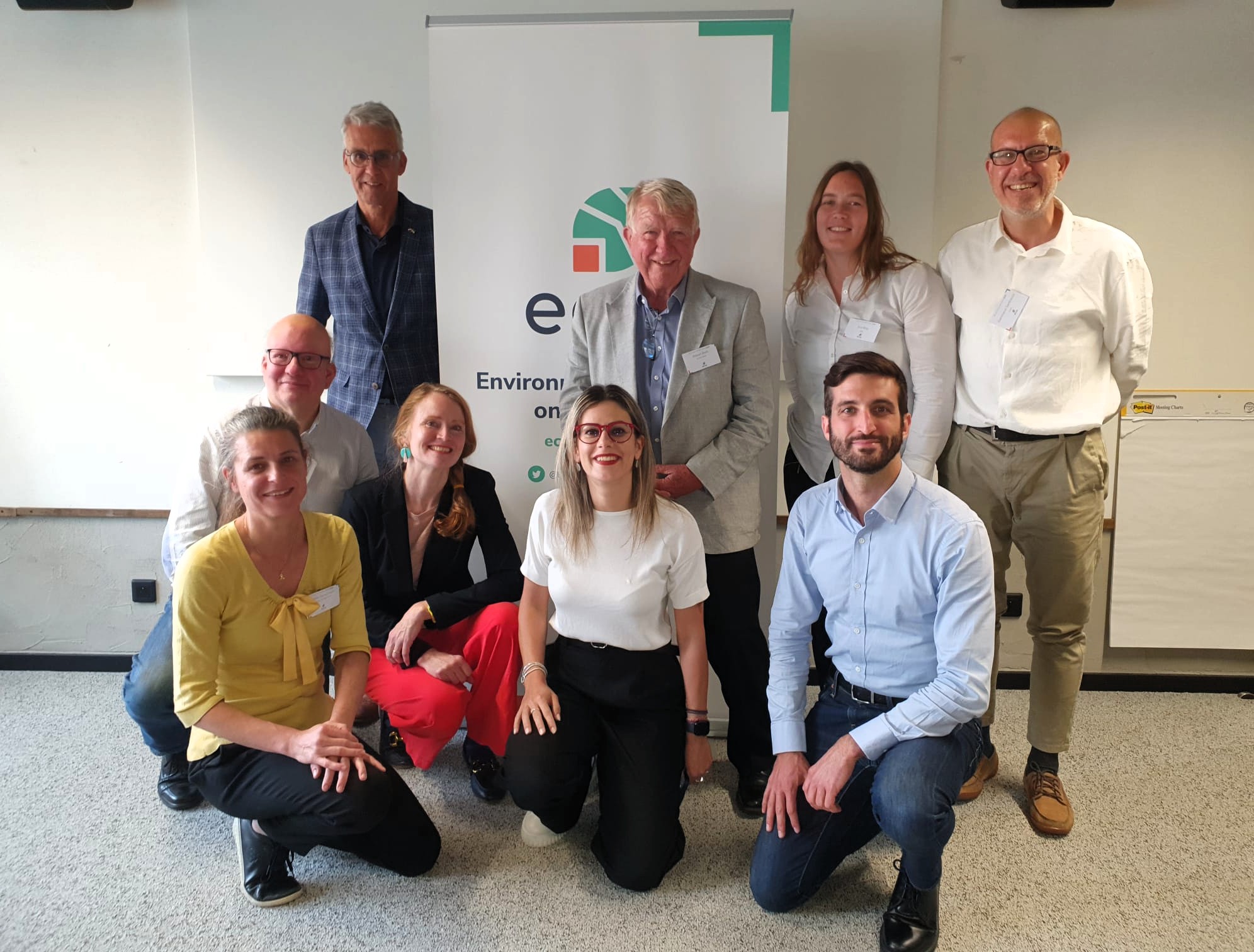 ECOS Executive Committee members are posing in front of the ECOS banner.